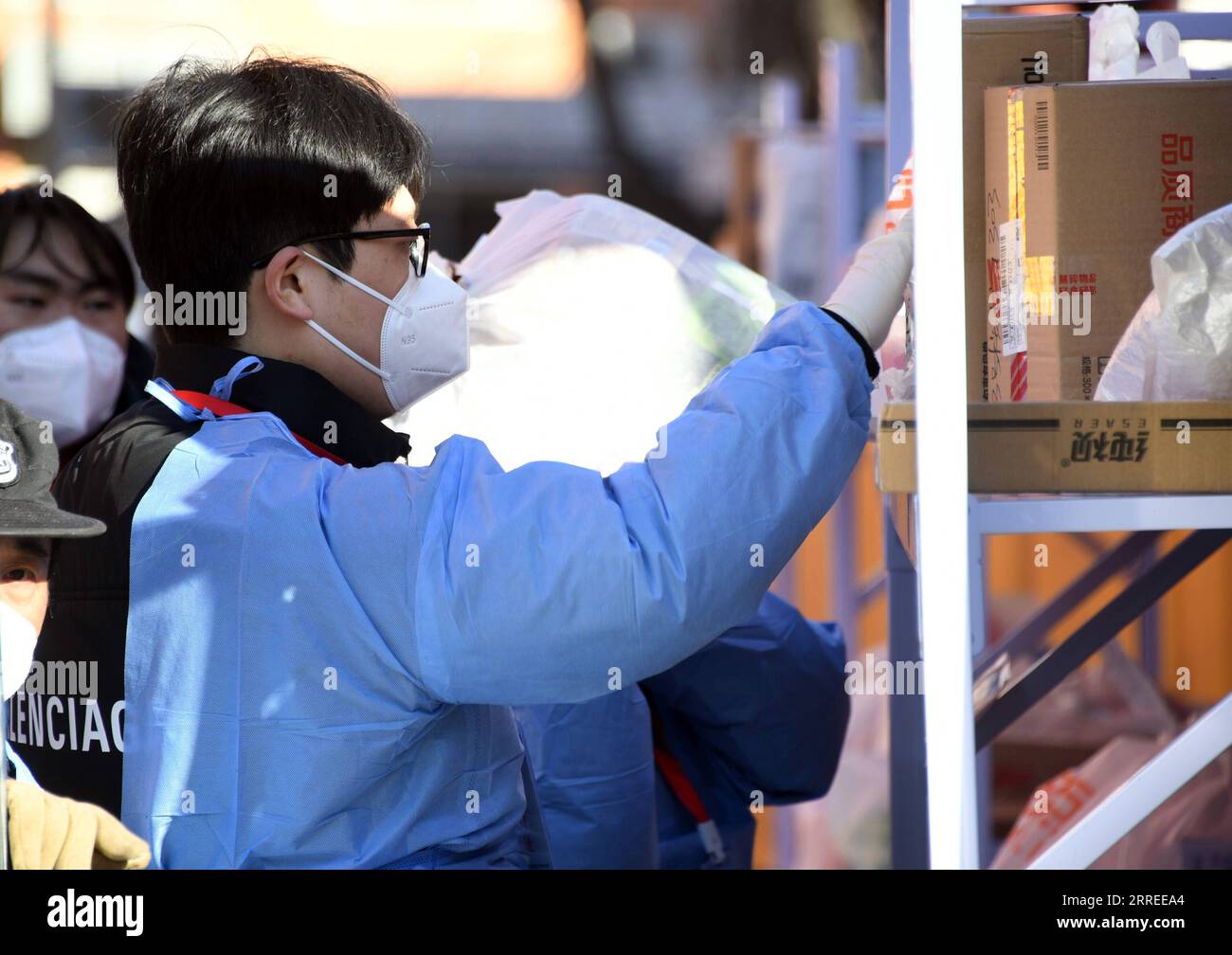 220223 -- PECHINO, 23 febbraio 2022 -- Un membro del personale organizza un'area di ritiro per consegne espresso in un complesso residenziale nel distretto di Haidian di Pechino, capitale della Cina, 23 febbraio 2022. Pechino ha riportato otto casi confermati di COVID-19 trasmessi localmente dalle 11:00 martedì alle 11:00 mercoledì, le autorità locali hanno detto mercoledì. I casi provengono dall'area di sviluppo economico-tecnologico di Pechino, dal distretto di Chaoyang, dal distretto di Tongzhou, dal distretto di Shunyi e dal distretto di Xicheng, secondo un comunicato stampa tenuto dal governo municipale. CINA-PECHINO-COVID-19 MISURE CN RENXCHAO PUBLI Foto Stock