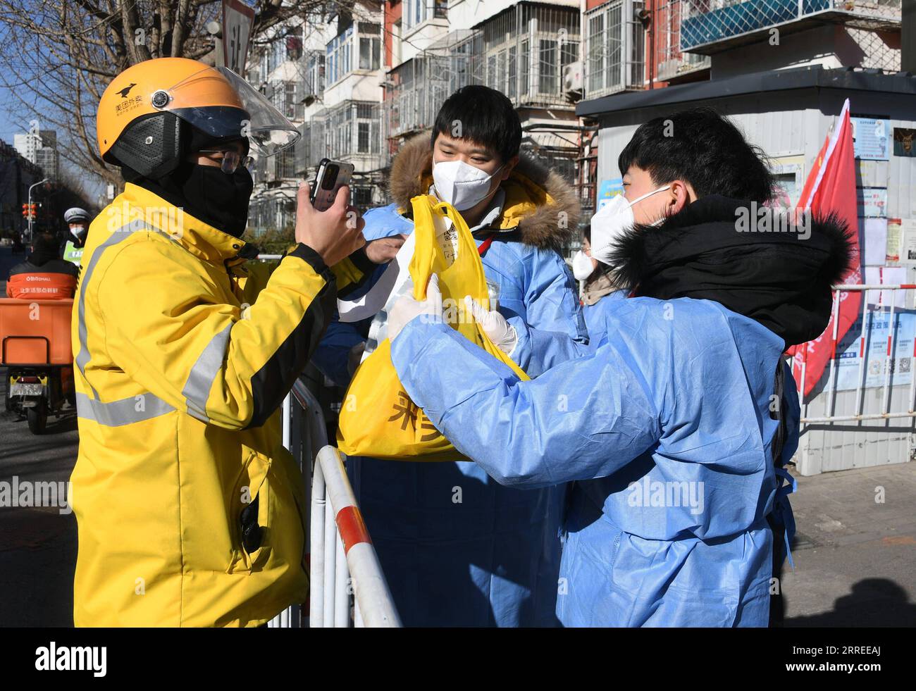 220223 -- PECHINO, 23 febbraio 2022 -- Un corriere consegna di cibo consegna ordini effettuati da residenti fuori da un complesso residenziale nel distretto di Haidian di Pechino, capitale della Cina, 23 febbraio 2022. Pechino ha riportato otto casi confermati di COVID-19 trasmessi localmente dalle 11:00 martedì alle 11:00 mercoledì, le autorità locali hanno detto mercoledì. I casi provengono dall'area di sviluppo economico-tecnologico di Pechino, dal distretto di Chaoyang, dal distretto di Tongzhou, dal distretto di Shunyi e dal distretto di Xicheng, secondo un comunicato stampa tenuto dal governo municipale. CINA-PECHINO-COVID-19 MISURE CN RENXCHAO PUBLICAT Foto Stock