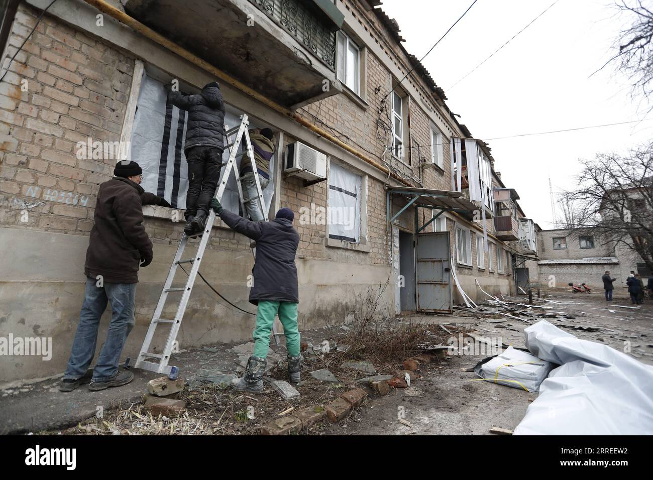 220225 -- DONETSK, 25 febbraio 2022 -- i residenti locali controllano gli appartamenti danneggiati a Yasinovataya, Donetsk, il 24 febbraio 2022. Str/Xinhua PER ANDARE CON la Russia conduce un'operazione militare speciale a Donbass Stringer PUBLICATIONxNOTxINxCHN Foto Stock