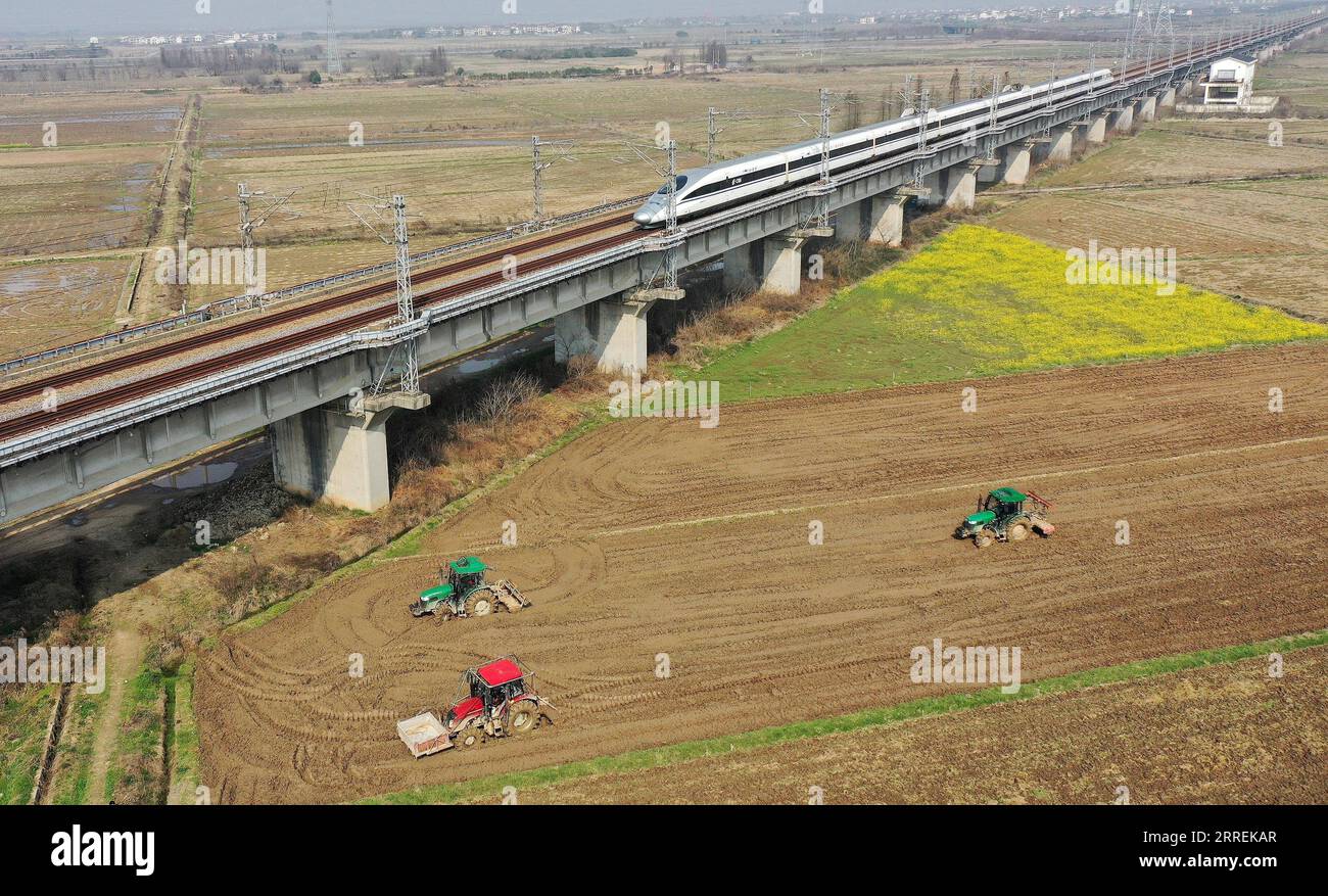 220306 -- NANCHANG, 6 marzo 2022 -- foto aerea scattata il 2 marzo 2022 mostra i macchinari agricoli che operano sul campo nel villaggio di Jin An, nella città di Gangshang nella contea di Nanchang, nella provincia del Jiangxi della Cina orientale. GU Daopeng è un agricoltore di 47 anni che lavora da 30 anni. Si è sviluppato da agricoltore che coltivava pochi ettari di terreno agricolo a capo di una cooperativa agricola con dozzine di macchinari agricoli e più di 2.700 mu 180 ettari di terreno. È felice che suo figlio GU Bingfa sia tornato nella loro città natale ed è impegnato nell'agricoltura con lui dopo essersi diplomato all'univ Foto Stock