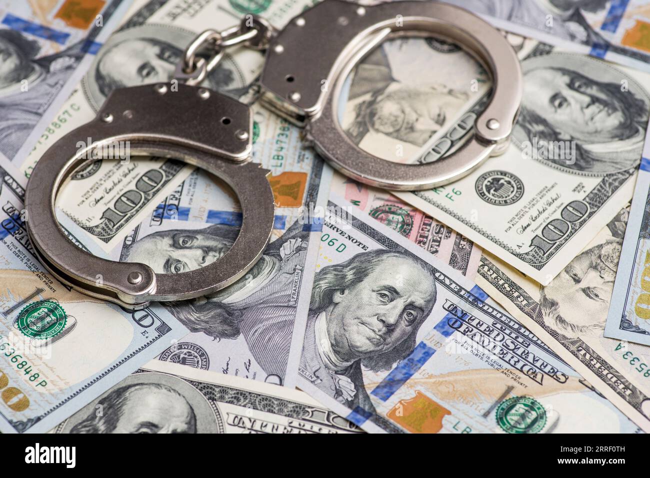 Banconote da dollari, soldi, soldi sporchi crimini finanziari e manette della polizia Foto Stock