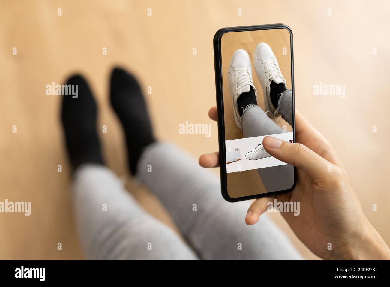 Donna che prova i sneakers virtuali in negozio o App Store AR Foto Stock