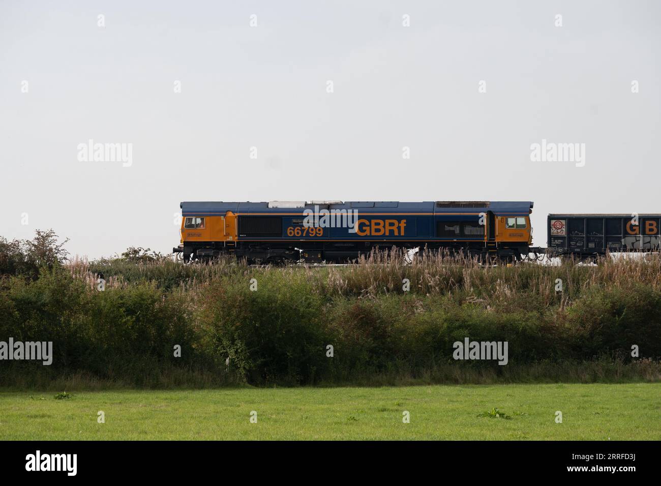 Locomotiva diesel GBRf classe 66 n. 66799 "Modern Railways Diamond Jubilee" che tira un treno merci, Warwickshire, Inghilterra, Regno Unito Foto Stock