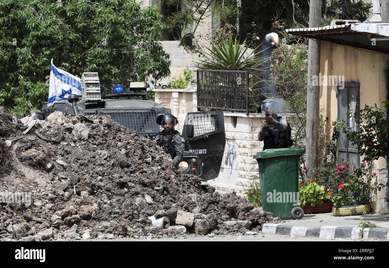 220419 -- NABLUS, 19 aprile 2022 -- Un membro della polizia di frontiera israeliana spara una tanica di gas lacrimogeni ai manifestanti palestinesi nel villaggio di Burqa vicino alla città di Nablus in Cisgiordania, il 19 aprile 2022. Foto di /Xinhua MIDEAST-NABLUS-CLASHES AymanxNobani PUBLICATIONxNOTxINxCHN Foto Stock