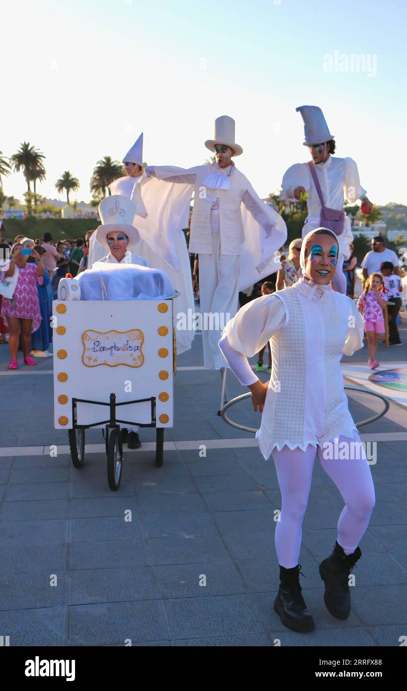 Spettacoli di circo Bambolea evento pubblico su palafitte e una ragazza con canestro e costumi bianchi vicino a Piquio Sardinero Santander Cantabria Spagna Foto Stock