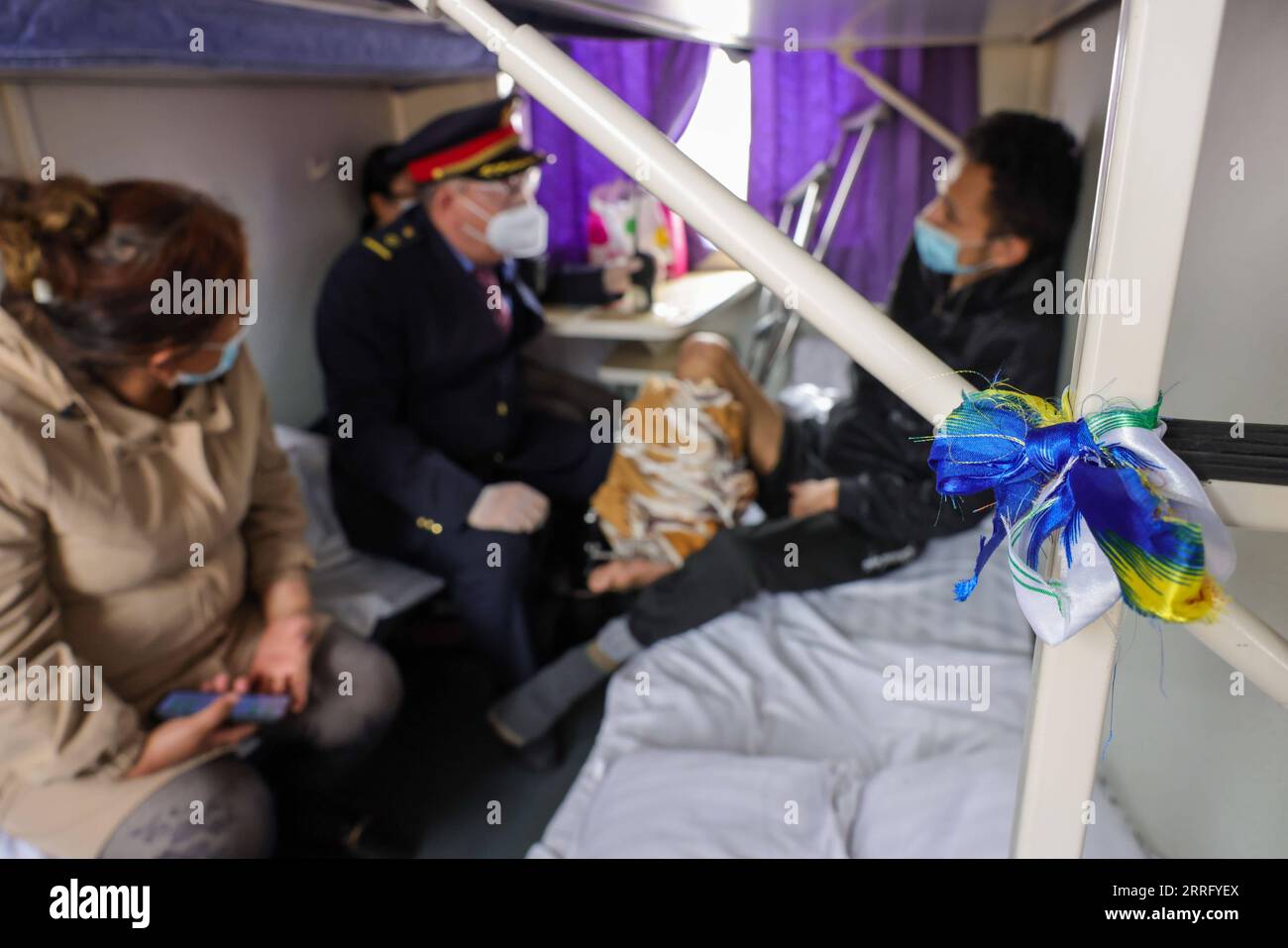 220430 -- KASHGAR, 30 aprile 2022 -- Un conduttore di treno apprende le condizioni di salute di un passeggero con disabilità a bordo di un treno lento diretto a Hotan nella regione autonoma di Xinjiang Uygur della Cina nord-occidentale, 27 aprile 2022. Mentre i treni ad alta velocità sfrecciano attraverso le stazioni in molte parti della Cina, i treni apparentemente obsoleti e a bassa velocità hanno continuato a servire i residenti di aree remote con prezzi e servizi dei biglietti stabili. Anche se ospita la rete ferroviaria ad alta velocità più sviluppata al mondo, la Cina gestisce ancora regolarmente 81 servizi di treno lento. I treni 7556/7557 e 7558/7555, in marcia Foto Stock