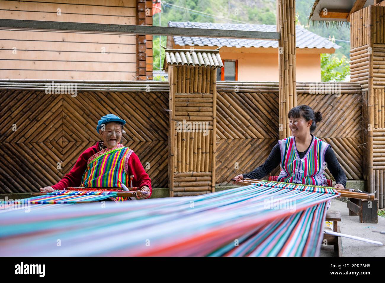 220513 -- GONGSHAN, 13 maggio 2022 -- la residente di Dulong li Wenshi L e sua figlia tessono coperte Dulong nel villaggio di Dizhengdang della città di Dulongjiang, Gongshan Dulong e Nu Autonomous County, provincia dello Yunnan della Cina sud-occidentale, 10 maggio 2022. Dulong è un gruppo etnico di montagna nel sud-ovest della Cina. E' una delle minoranze etniche cinesi meno popolose. Nel 2018, il gruppo etnico Dulong ha sconvolto la povertà nel suo insieme, una svolta fenomenale. Li Wenshi, ereditando le abilità di tessitura della coperta Dulong da sua madre, ha usato la sua esperienza per creare vari prodotti che sono popolari AM Foto Stock