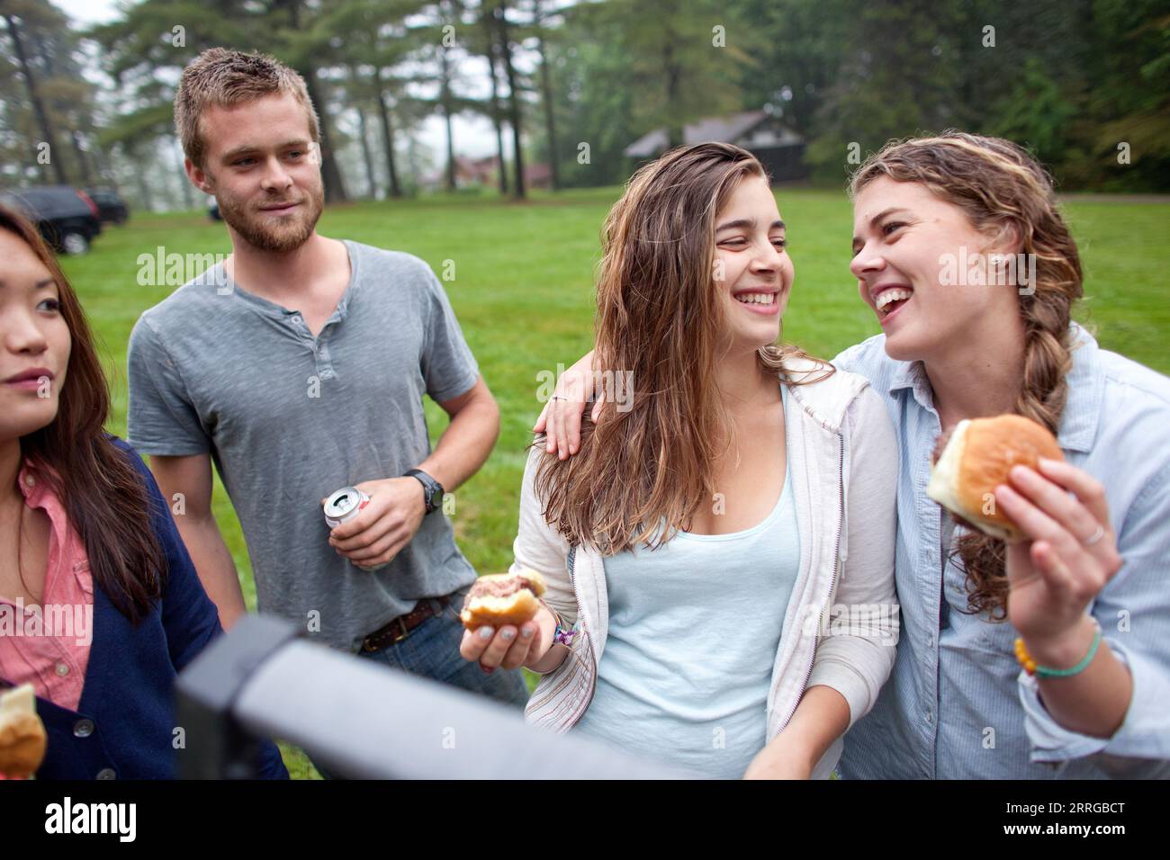 Amici che escono e mangiano hamburger al barbecue Foto Stock