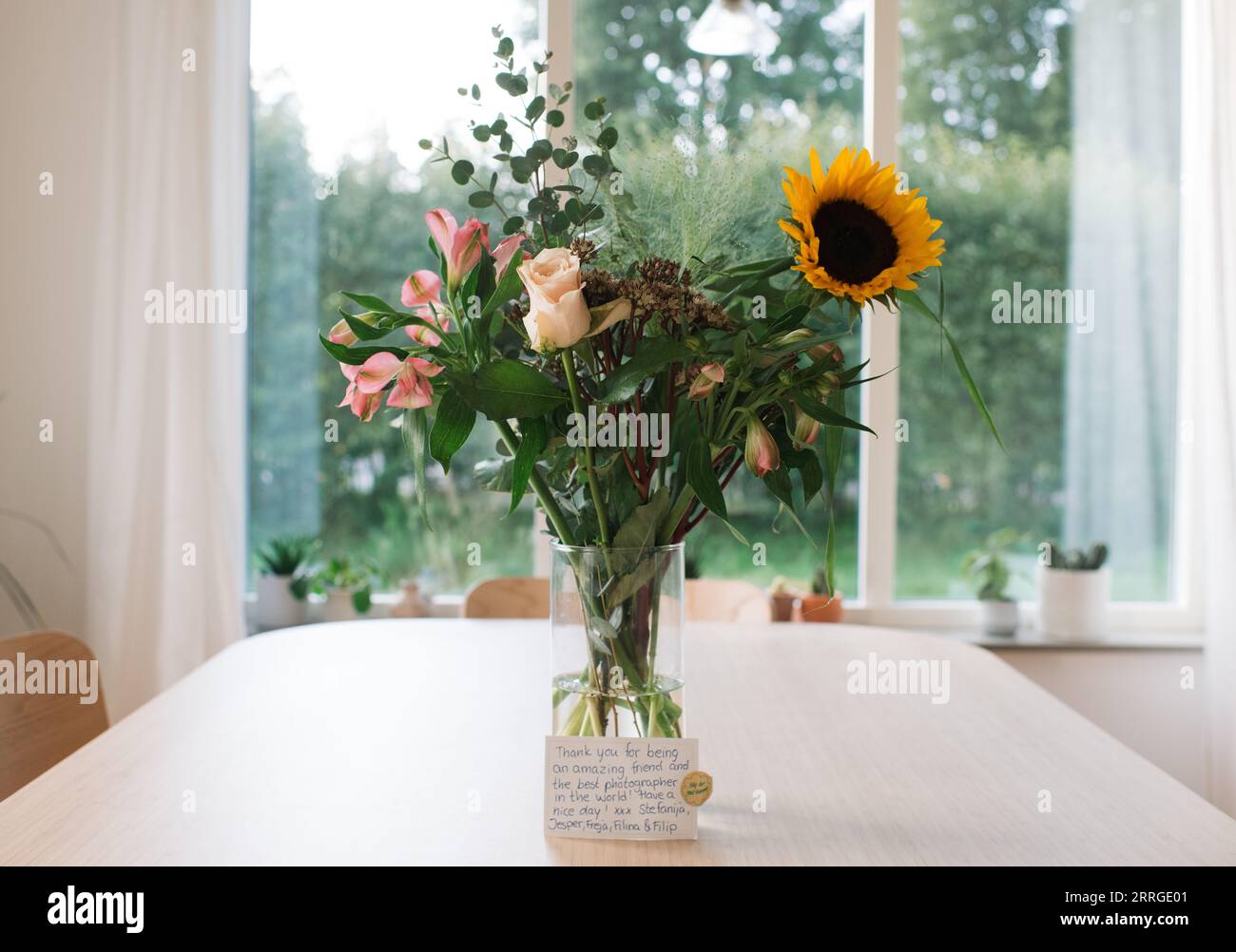 grazie fiori e biglietto su un tavolo a casa Foto Stock