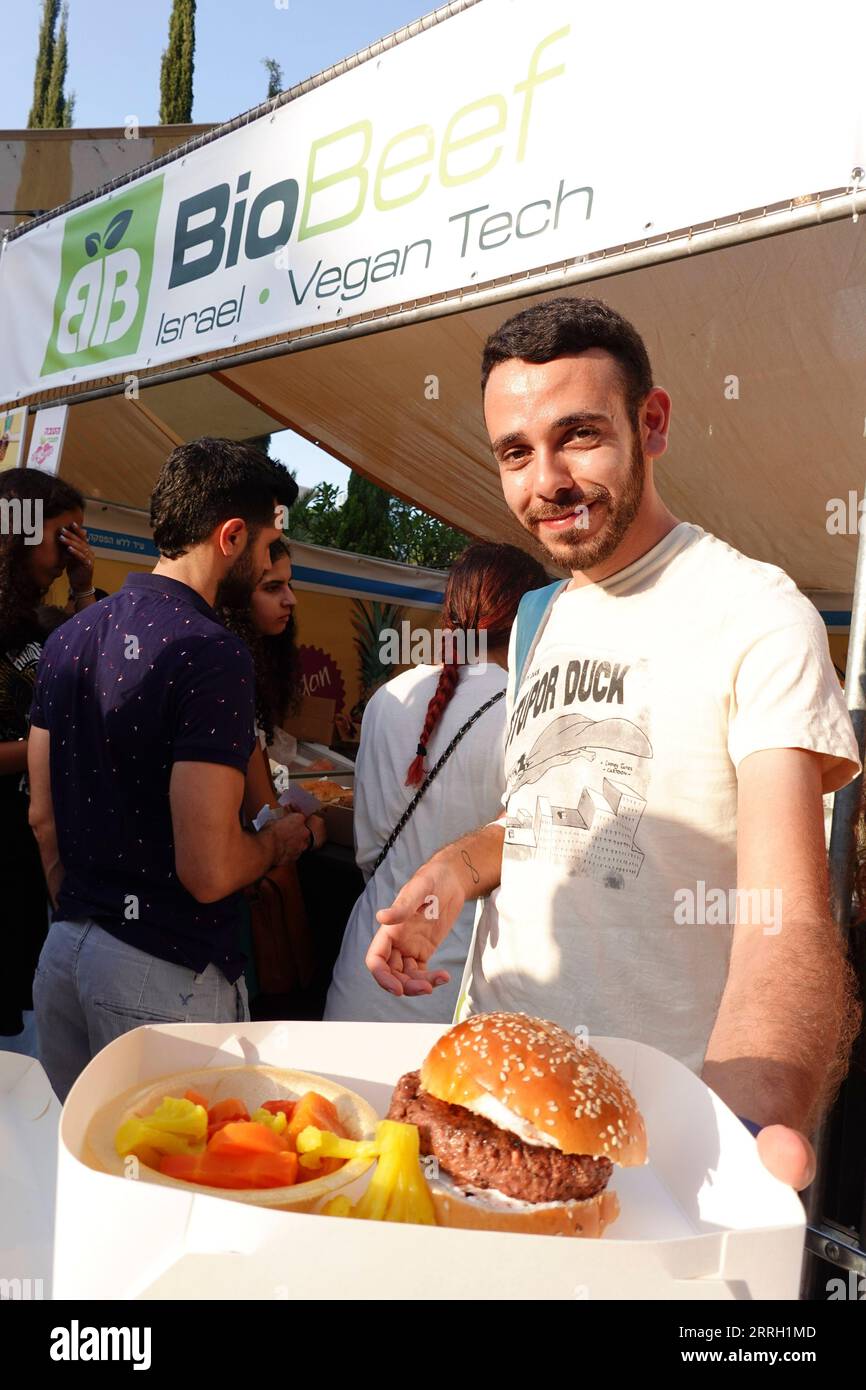 220608 -- TEL AVIV, 8 giugno 2022 -- Un uomo mostra un hamburger a base vegetale ad un festival vegano a Tel Aviv, Israele, il 7 giugno 2022. Il festival si svolge dal 7 al 9 giugno nel parco Sarona di Tel Aviv. ISRAEL-TEL AVIV-VEGAN FESTIVAL WangxZhuolun PUBLICATIONxNOTxINxCHN Foto Stock