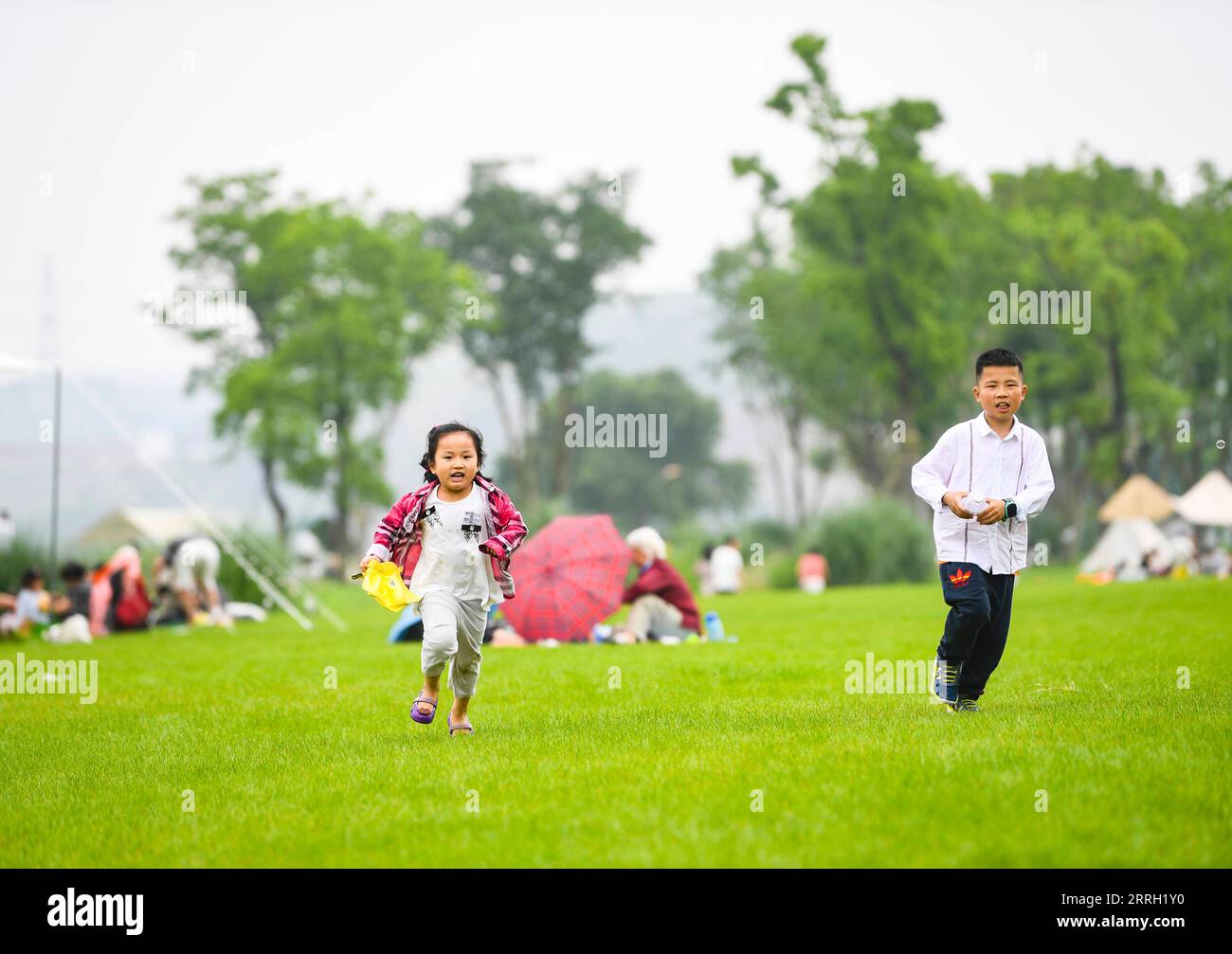 220608 -- CHONGQING, 8 giugno 2022 -- i bambini si divertono nell'isola di Guangyang a Chongqing, nel sud-ovest della Cina, 5 giugno 2022. L'isola di Guangyang, la più grande isola sulla parte superiore del fiume Yangtze, è ricca di risorse naturali. Negli ultimi anni sono state adottate una serie di misure per ripristinare l'ambiente ecologico dell'isola, attirando i turisti nei suoi campi colorati. CHINA-CHONGQING-GUANGYANG ISLE-TOURISM CN WANGXQUANCHAO PUBLICATIONXNOTXINXCHN Foto Stock