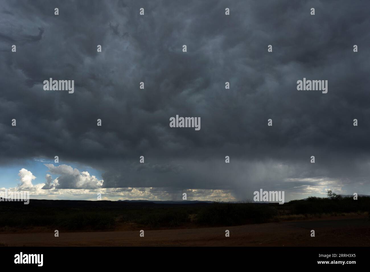 Nuvole di tempesta oscure sul paesaggio desertico Foto Stock