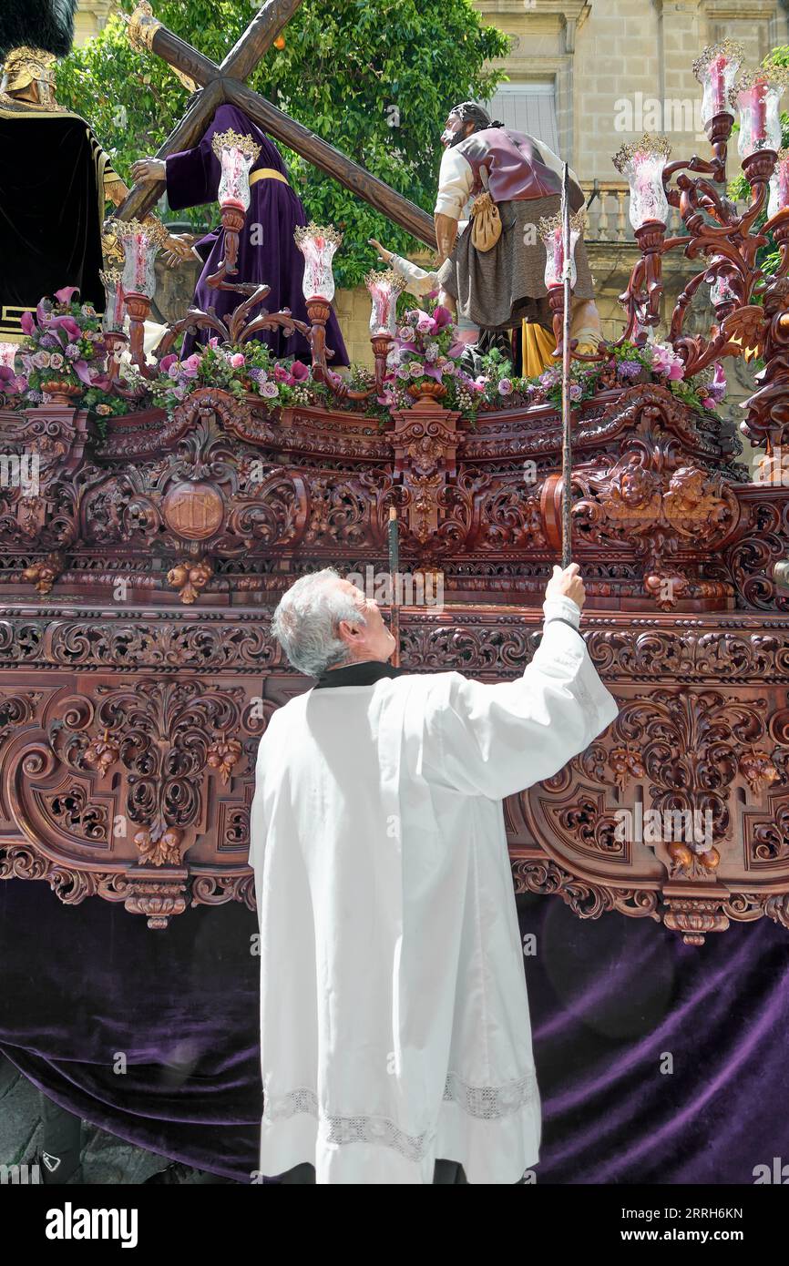 Jerez de la Frontera, Spagna - 8 settembre 2023: Il sacerdote accende le candele del Paso durante la settimana Santa a Jerez de la Frontera in Andalusia, Spagna. Foto Stock