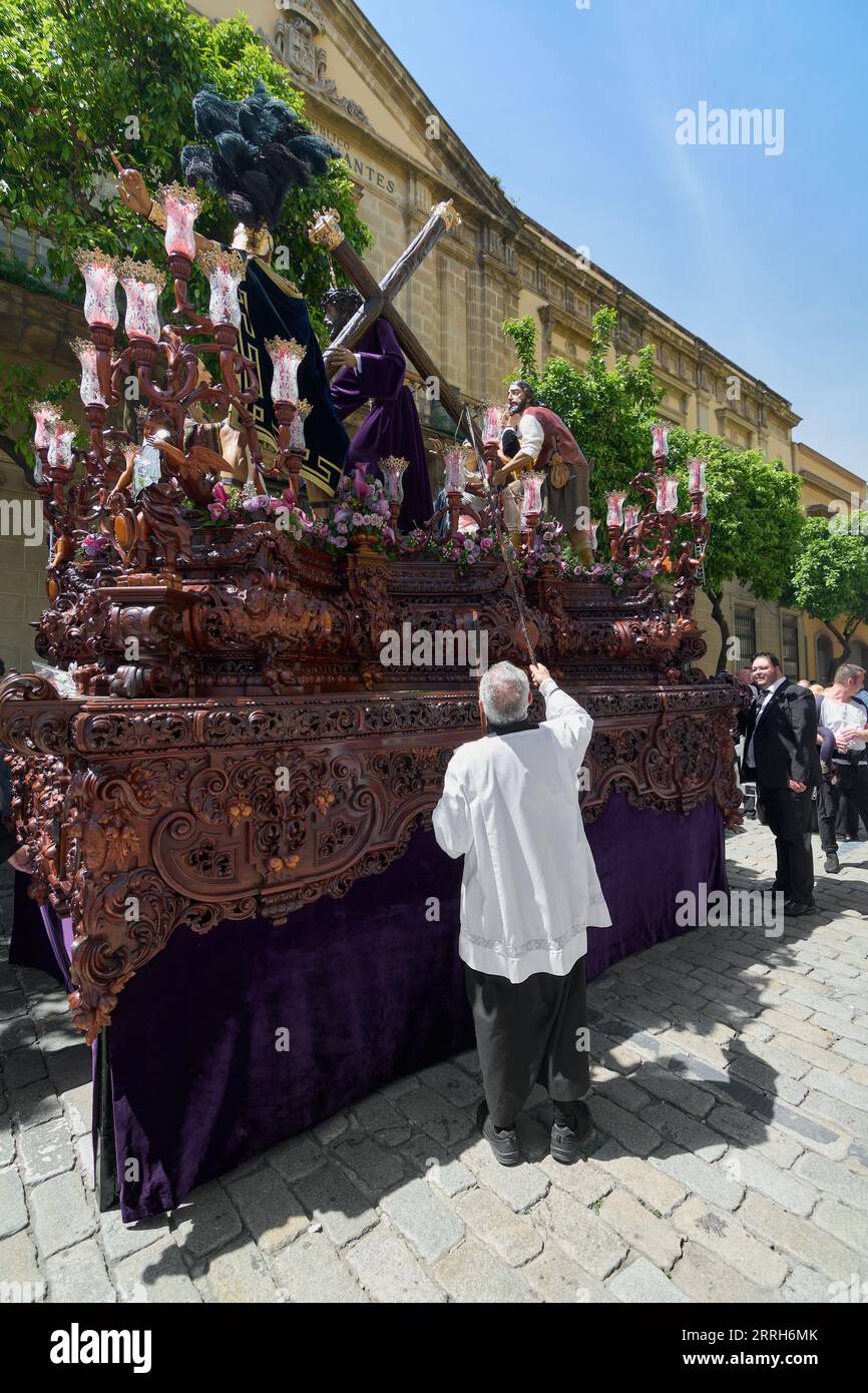 Jerez de la Frontera, Spagna - 8 settembre 2023: Il sacerdote accende le candele del Paso durante la settimana Santa a Jerez de la Frontera in Andalusia, Spagna. Foto Stock