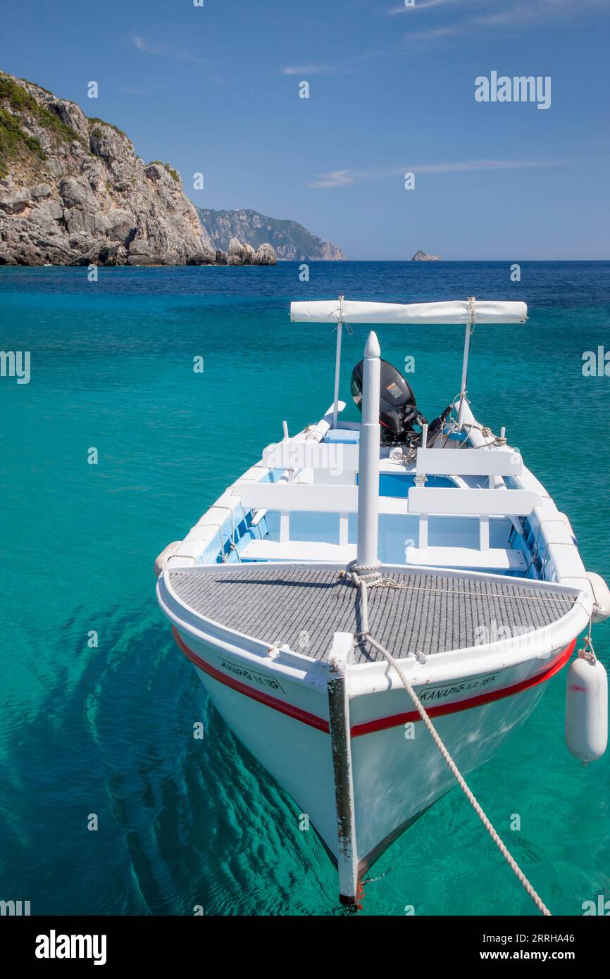 Barca bianca sulle acque cristalline al largo della costa di Korfù, Grecia Foto Stock