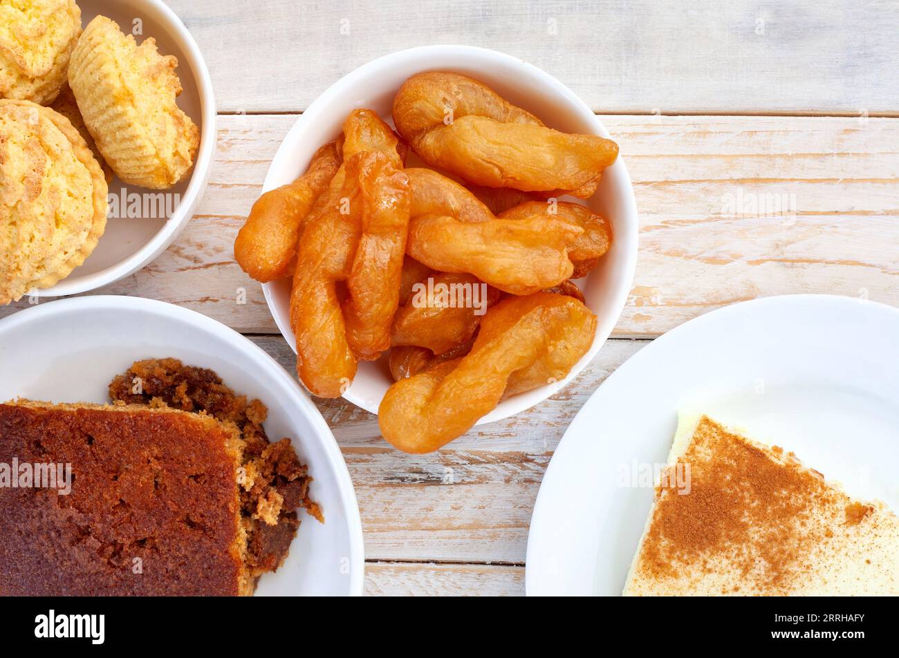 Tradizionale cibo dolce sudafricano su legno rustico. Crostata di latte, sorelle koek e budino di malva Foto Stock