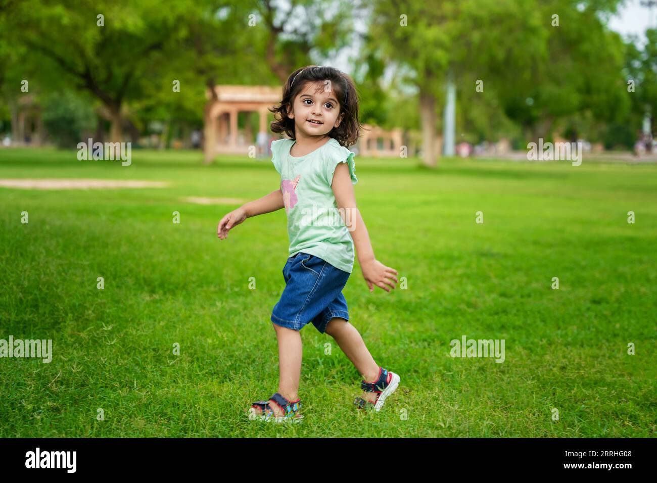 Simpatica e carina bambina indiana che si diverte al parco estivo o al giardino. Foto Stock