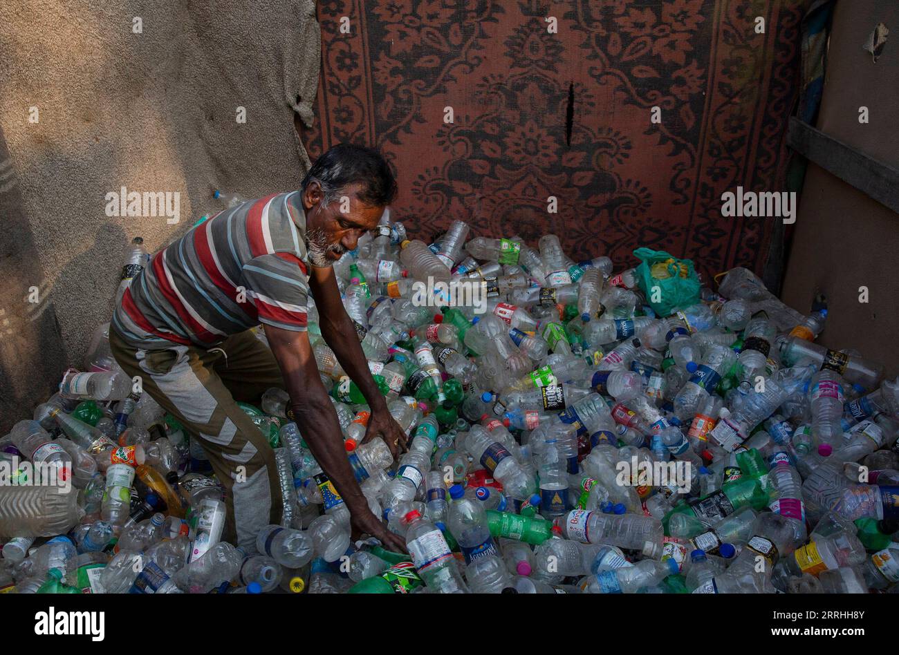 220702 -- SRINAGAR, 2 luglio 2022 -- Un ragpicker organizza bottiglie di plastica a Srinagar, capitale estiva del Kashmir controllato dagli indiani, 1 luglio 2022. Il governo indiano ha istituito sale di controllo dedicate e ha formato squadre speciali per controllare la produzione illegale, l'importazione, lo stoccaggio, la distribuzione, la vendita e l'uso di articoli SUP monouso in plastica vietati. A tutti gli stati e territori del paese è stato chiesto di istituire posti di controllo di frontiera per fermare il movimento interstatale di qualsiasi articolo di SUP vietato, ha detto un annuncio ufficiale, che ha ribadito un divieto totale di uso di SUP nel paese con effetto da Ju Foto Stock