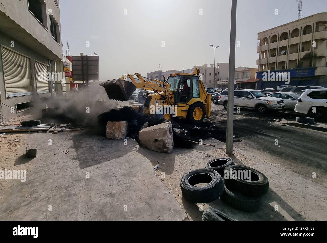 220702 -- TRIPOLI, 2 luglio 2022 -- Una pala gommata rimuove i detriti su una strada dopo le proteste a Tajoura, Tripoli orientale, Libia, il 2 luglio 2022. Venerdì sono scoppiate proteste in diverse città libiche per la situazione di stallo politico del paese, con manifestanti che chiedono lo scioglimento di tutti gli organi politici esistenti e che si tengano al più presto le elezioni presidenziali e parlamentari. Foto di /Xinhua LIBIA-TRIPOLI-PROTEST-AFTERMATH HamzaxTurkia PUBLICATIONxNOTxINxCHN Foto Stock