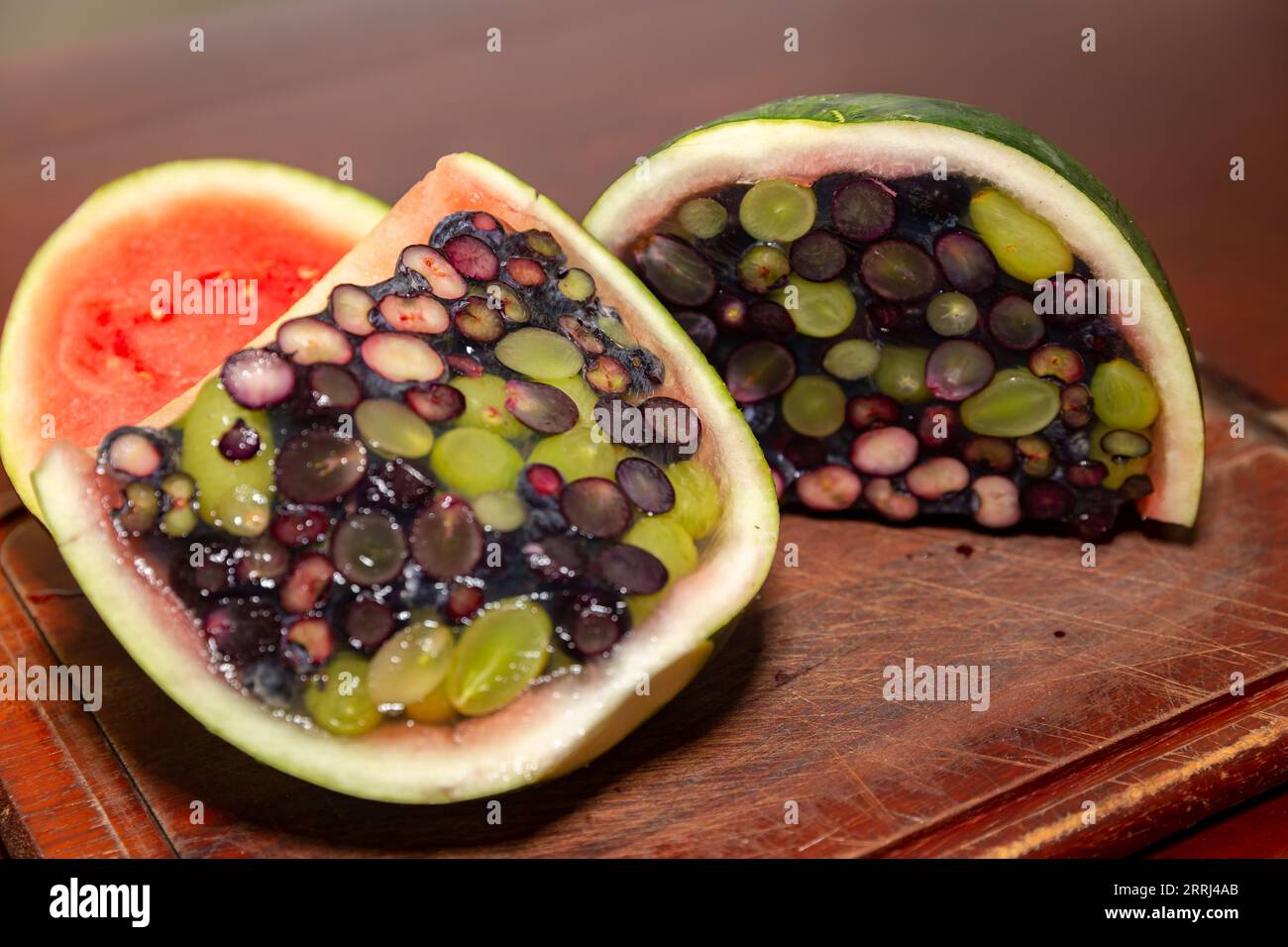 Aprire un cocomero riempito di gelatina e frutti di bosco. Dessert interessante e diverso Foto Stock