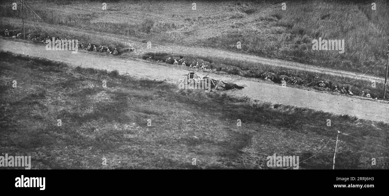 "Du tardenois a la Picardie; premiere ligne dans le fosse d'une Route, devant fate-en-Tardenois; sur le Route, un caisson ennemi atteint par un obus pendant la retraite allemande", 1918. Da "l'album de la Guerre 1914-1919, volume 2" [l'Illustration, Paris, 1924]. Foto Stock