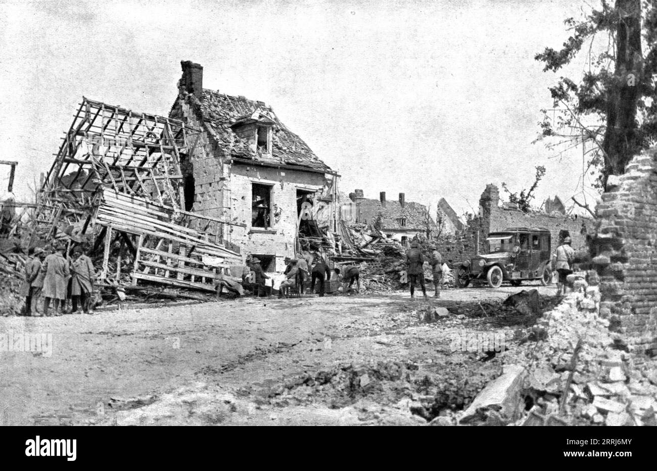 "Dans Montdidier libere; dejeuner de campagne, a l'entre de Montdidier, de M. Clemenceau venu visiter al ville le 11 aout; en face du President du Conseil, a la table dressee devant une maison en ruines, est assis M. Klotz, ministre des finances, depute de l'arrondissement de Montdidier", 1918. Da "l'album de la Guerre 1914-1919, volume 2" [l'Illustration, Paris, 1924]. Foto Stock