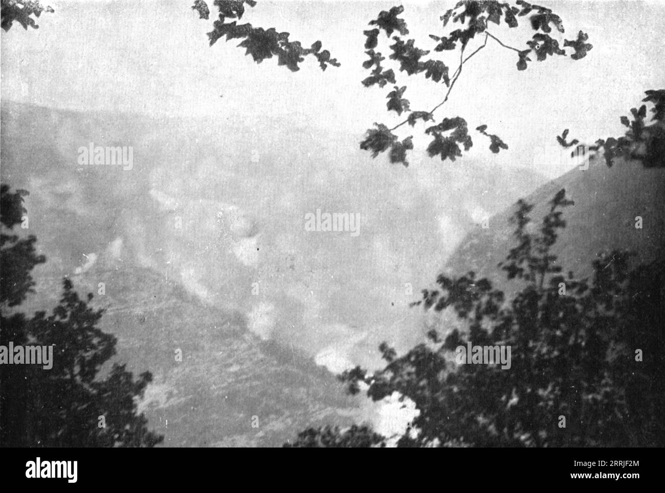 "Victorieuse Offensive Italienne; le bombardement italien sur la chaine du Cucco et du Santo, le 12 mai: les eclatements couvrent la montagne d'une sorte de brouillard", 1917. Prima guerra mondiale: Offensiva italiana; bombardamento italiano sulla catena del Cucco e del Santo, le montagne sono nascoste in una nebbia di esplosioni, 12 maggio 1917. Da "l'album de la Guerre 1914-1919, volume 2" [l'Illustration, Paris, 1924]. Foto Stock