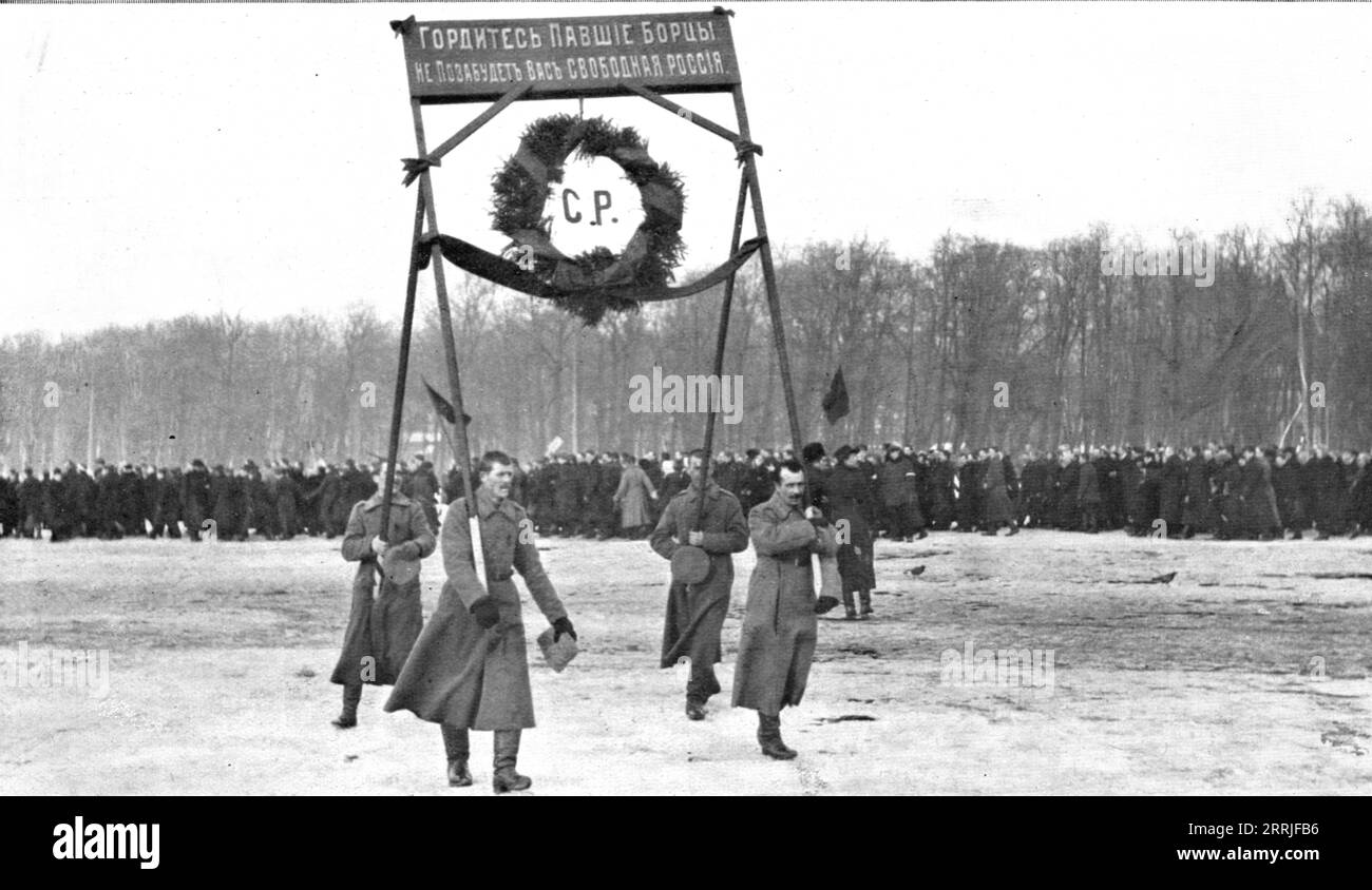 "Les Funerailles des Morts de la Revolution; un hommage de l'armee revolutionnaire: Soldats portant une couronne surmontee de cette inscription en lettres d'or, sur fond rouge: &Lt;&lt;Soyez fiers, lutteurs Tomb&#xe9;s, la Russie libre ne vous oubliera pas. &gt;&gt;', 1917. La rivoluzione russa: Funerali dei caduti. Omaggio dell'esercito rivoluzionario, soldati che trasportano una corona d'oro su sfondo rosso: "Siate orgogliosi, combattenti caduti, la Russia libera non vi dimenticherà". Da "l'album de la Guerre 1914-1919, volume 2" [l'Illustration, Paris, 1924]. Foto Stock