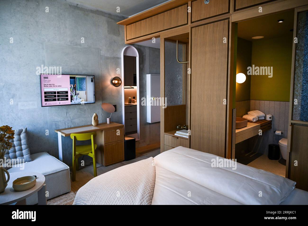 PRODUZIONE - 06 settembre 2023, Berlino: L'Aparthotel Eastside Locke direttamente sulla Sprea. Con Locke alla East Side Gallery, il marchio di aparthotel Locke è ora rappresentato anche con una sede a Berlino. Comprende 176 monolocali con angolo cottura e aree soggiorno tipiche del marchio dell'hotel. Le camere sono decorate in tonalita' neutre, mentre tessuti naturali, come tappeti in erba intrecciati grossolanamente, testiere in rattan e cemento a vista con finiture in polvere, aggiungono sapientemente accenti. Le pareti delle camere sono parzialmente rivestite di legno, e il divisorio in vetro bruciato nel bagno è fatto per farlo Foto Stock