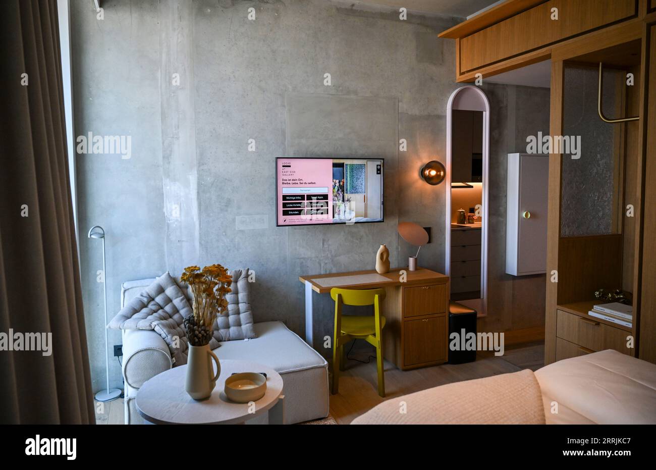 PRODUZIONE - 06 settembre 2023, Berlino: L'Aparthotel Eastside Locke direttamente sulla Sprea. Con Locke alla East Side Gallery, il marchio di aparthotel Locke è ora rappresentato anche con una sede a Berlino. Comprende 176 monolocali con angolo cottura e aree soggiorno tipiche del marchio dell'hotel. Le camere sono decorate in tonalita' neutre, mentre tessuti naturali, come tappeti in erba intrecciati grossolanamente, testiere in rattan e cemento a vista con finiture in polvere, aggiungono sapientemente accenti. Le pareti delle camere sono parzialmente rivestite di legno, e il divisorio in vetro bruciato nel bagno è fatto per farlo Foto Stock