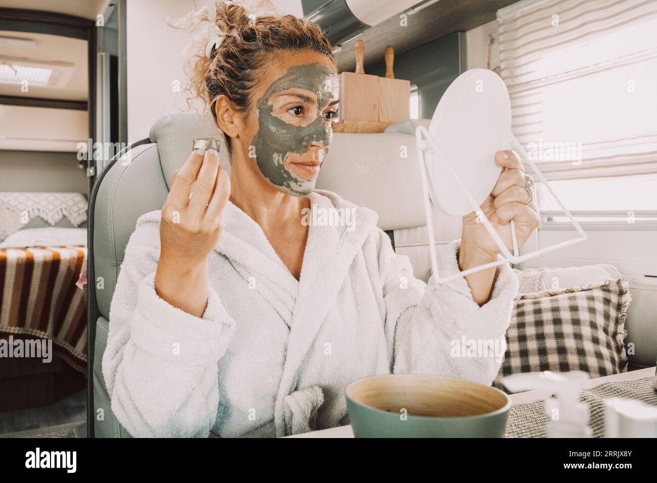 Una giovane donna adulta attraente che utilizza il trattamento naturale del prodotto maschera facciale per età e rughe benessere cura del corpo e routine quotidiana di amore di sé. Stile di vita sano donne al chiuso Foto Stock