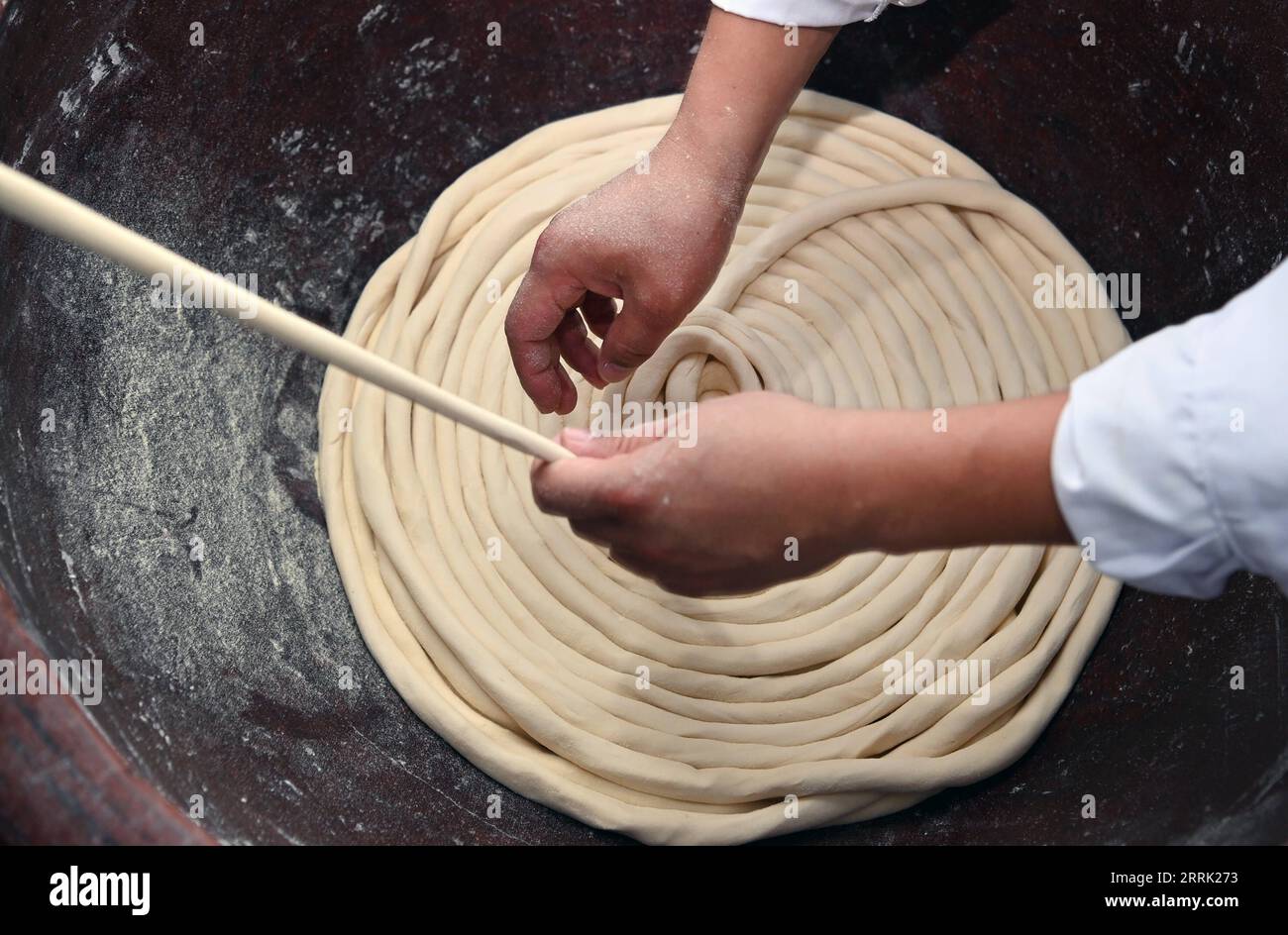 220817 -- LUONAN, 17 agosto 2022 -- li Changman produce spaghetti cavi nel villaggio di Meidi di Bao An Township nella contea di Luonan della città di Shangluo, provincia dello Shaanxi della Cina nord-occidentale, 16 agosto 2022. Li Changman, un abitante di 66 anni del villaggio di Meidi, ha imparato le abilità uniche di produzione di noodle cave da quando era adolescente. È l'erede delle abilità luonane fatte a mano per la produzione di noodle hallow che è elencato come patrimonio culturale immateriale provinciale. Incoraggiò suo figlio a imparare questa abilità, e insegnò anche le abilità agli abitanti del villaggio per aumentare il loro reddito. CHINA-SHAANXI-HOLLOW NOODLE CN TAOXMIN Foto Stock