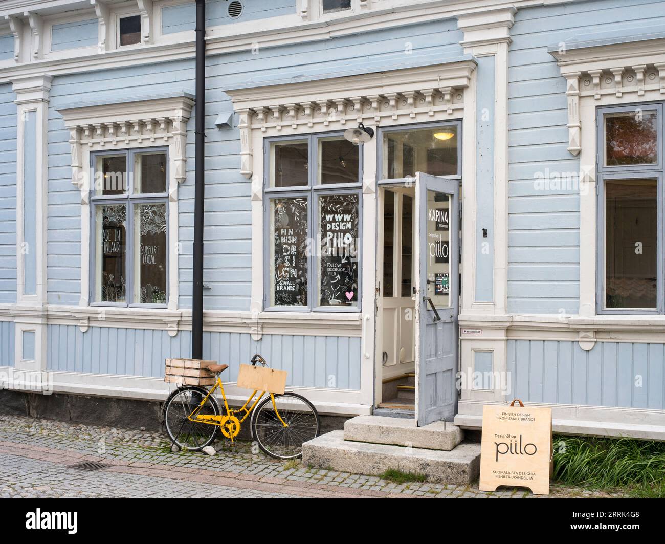 Scena stradale di Tallinn, bicicletta gialla di fronte alla facciata in legno, Estonia Foto Stock