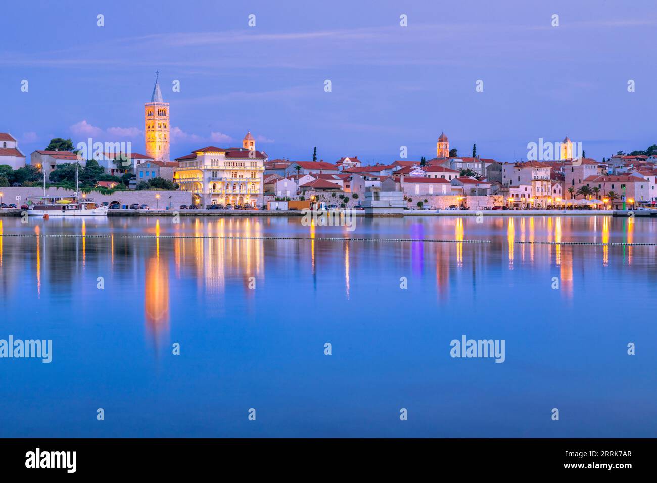 Europa, Croazia, Primorje-Gorski Kotar County, Rab Island, Rab, la città vecchia e gli edifici che si affacciano sul porticciolo al crepuscolo Foto Stock