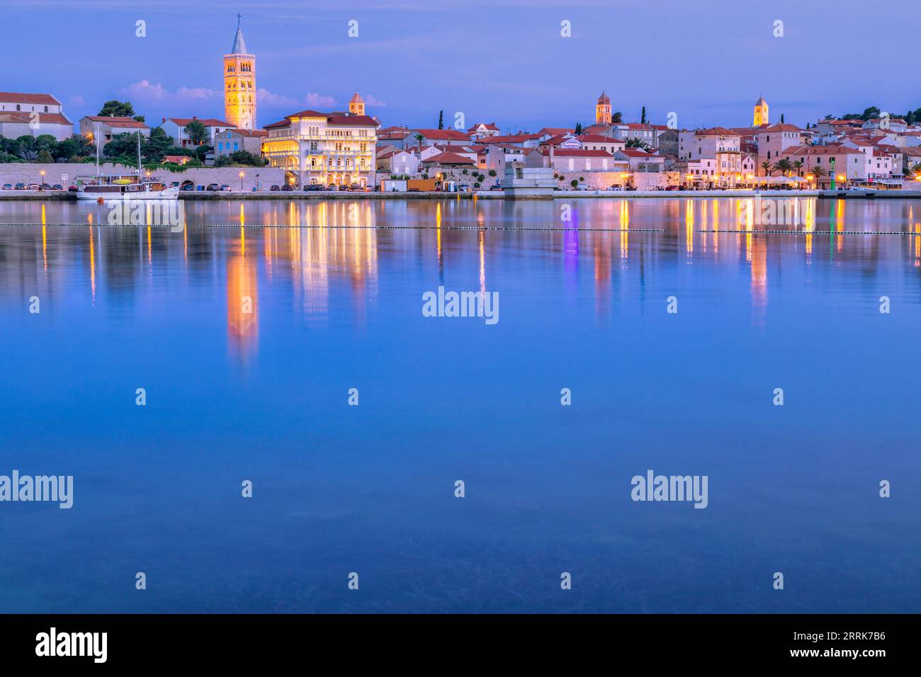 Europa, Croazia, Primorje-Gorski Kotar County, Rab Island, Rab, la città vecchia e gli edifici che si affacciano sul porticciolo al crepuscolo Foto Stock