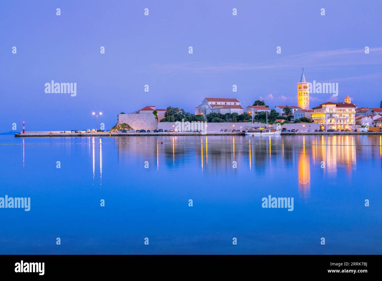 Europa, Croazia, Primorje-Gorski Kotar County, Rab Island, Rab, la città vecchia e gli edifici che si affacciano sul porticciolo al crepuscolo Foto Stock