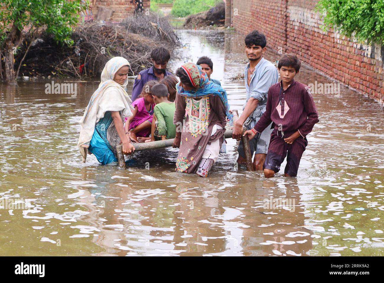 220825 -- TANDO ALLAHYAR, 25 agosto 2022 -- le persone colpite dalle inondazioni evacuano da un'area colpita dalle inondazioni nel distretto di Tando Allahyar, nella provincia di Sindh nel Pakistan meridionale il 25 agosto 2022. Ben 903 persone sono state uccise, quasi 1.300 ferite e migliaia hanno lasciato senza casa mentre le pesanti piogge monsoniche e le inondazioni improvvise hanno continuato a devastare il Pakistan da metà giugno, ha dichiarato mercoledì l'Autorità nazionale per la gestione dei disastri (NDMA). Str/Xinhua PAKISTAN-TANDO ALLAHYAR-FLOODS Stringer PUBLICATIONxNOTxINxCHN Foto Stock