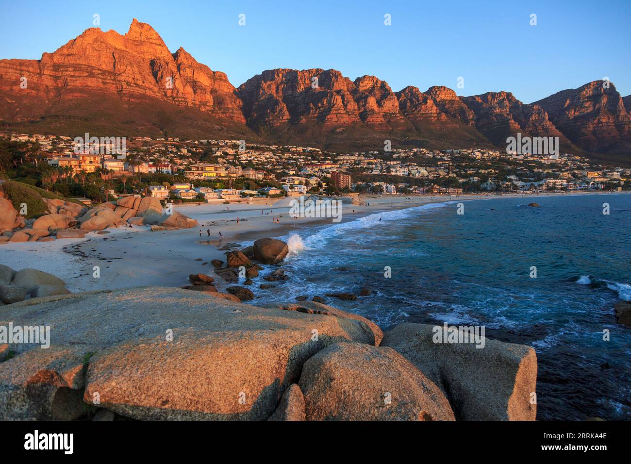 Sud Africa, città del Capo, Camps Bay, vista di Camps Bay al tramonto con luce rossastra, 12 Apostles Mountains Foto Stock