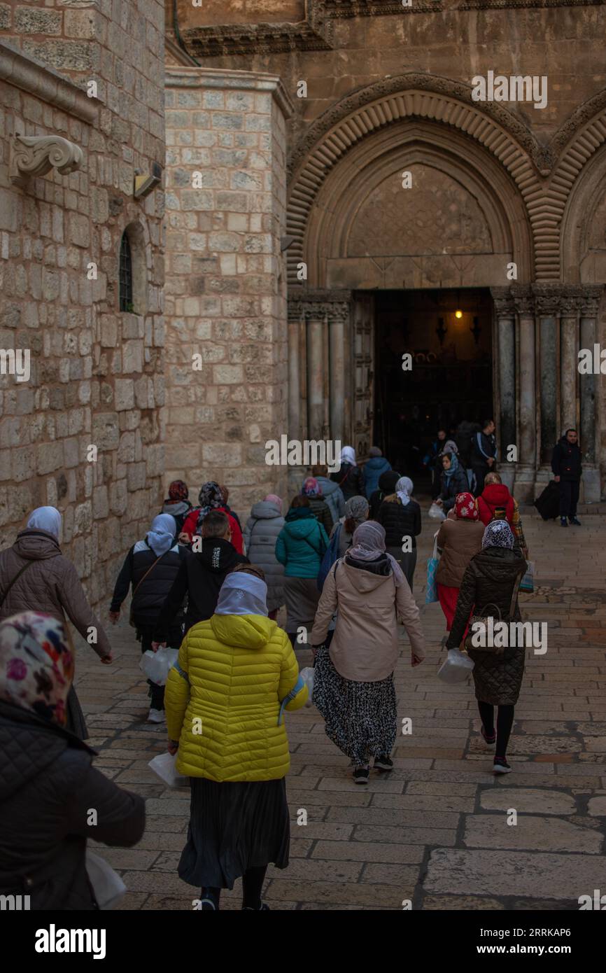 Una grande congregazione di persone, con croci in mano, scende i gradini di un edificio della chiesa Foto Stock