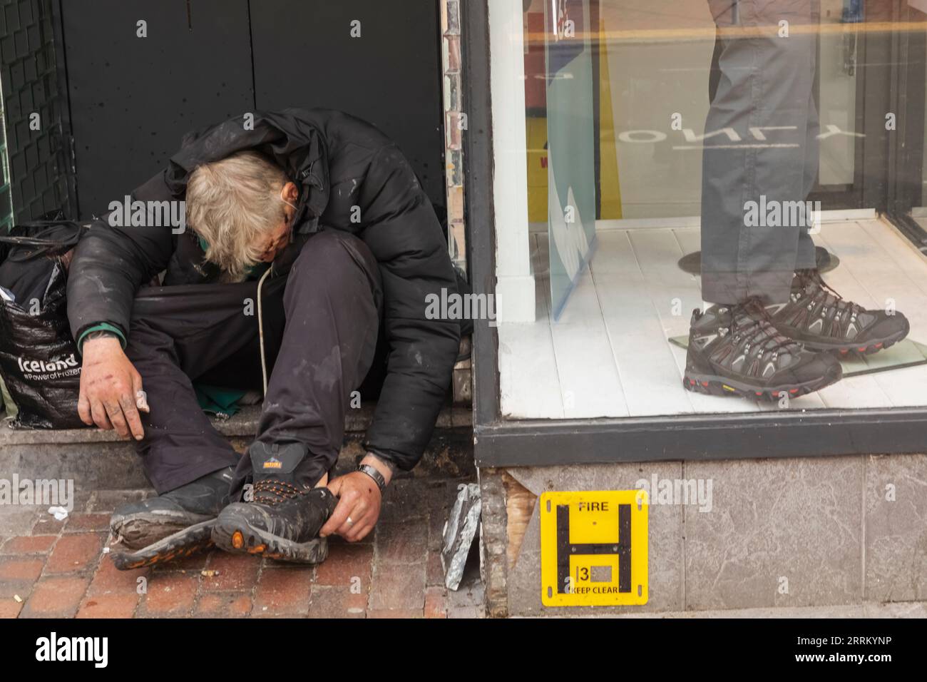Inghilterra, Sussex, East Sussex, Eastbourne, Homeless Man in Doorway e Shop Window Foto Stock
