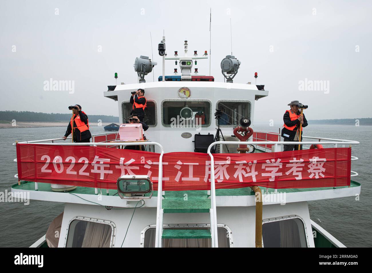 220924 -- WUHAN, 24 settembre 2022 -- i ricercatori usano il binocolo per condurre un lavoro di monitoraggio durante una spedizione scientifica sulle focene senza pinne di Yangtze nella sezione Shishou del fiume Yangtze, nella provincia centrale di Hubei della Cina, 23 settembre 2022. Lunedì la Cina ha lanciato un'indagine scientifica sulle focene senza pinne dello Yangtze, una specie iconica del fiume più lungo del paese, con l'obiettivo di formulare un piano di protezione più mirato per la specie. Organizzata dall'amministrazione della pesca del bacino fluviale dello Yangtze sotto il Ministero dell'Agricoltura e degli affari rurali, la spedizione è stata condotta congiuntamente Foto Stock