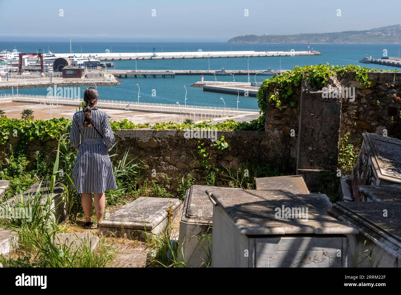Una donna che guarda al mare mentre soggiorna al cimitero ebraico di Tangeri, in Marocco Foto Stock