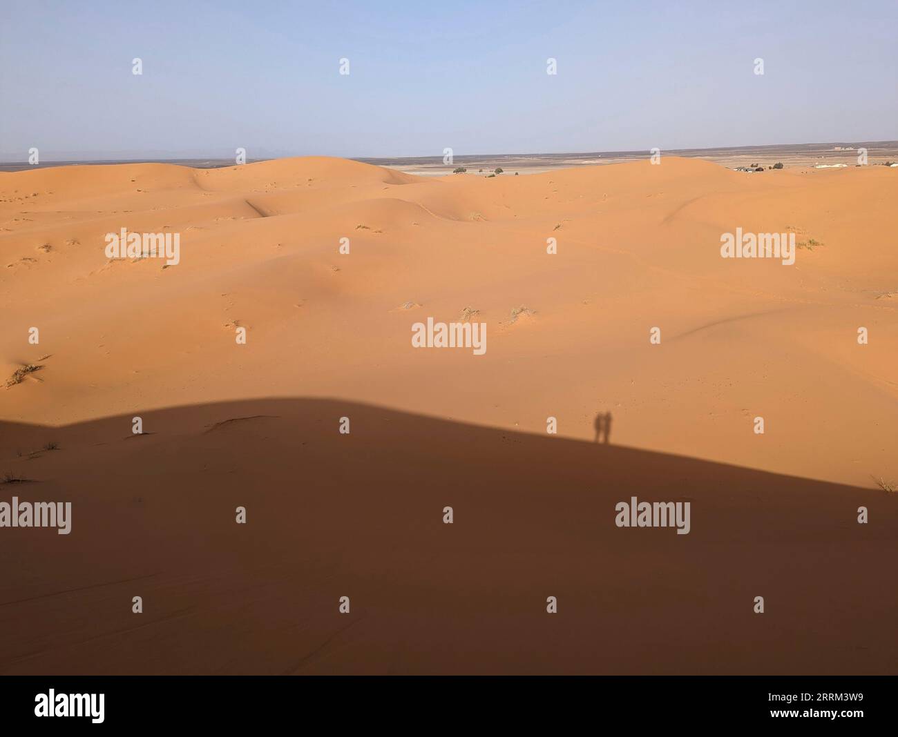 Un'ombra di due persone sulla Grande Duna di Merzouga nel deserto di Erg Chebbi nel Sahara Africano, deserto marocchino Foto Stock