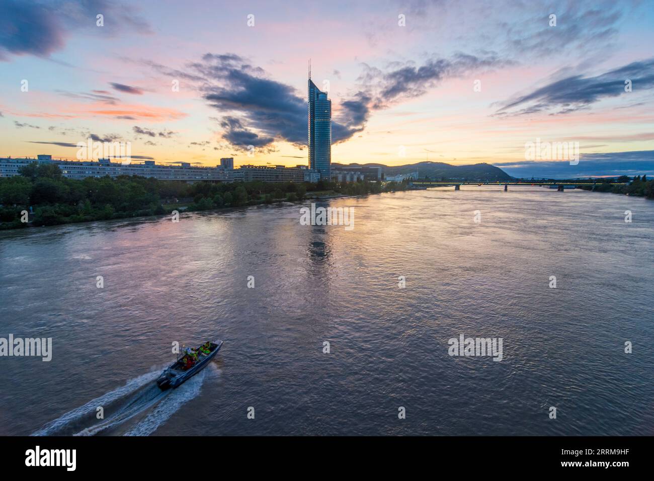 Vienna, fiume Donau (Danubio), Millennium Tower, ponte Nordbahnbrücke, nave di soccorso, tramonto tra 20. Distretto Brigittenau, Vienna, Austria Foto Stock