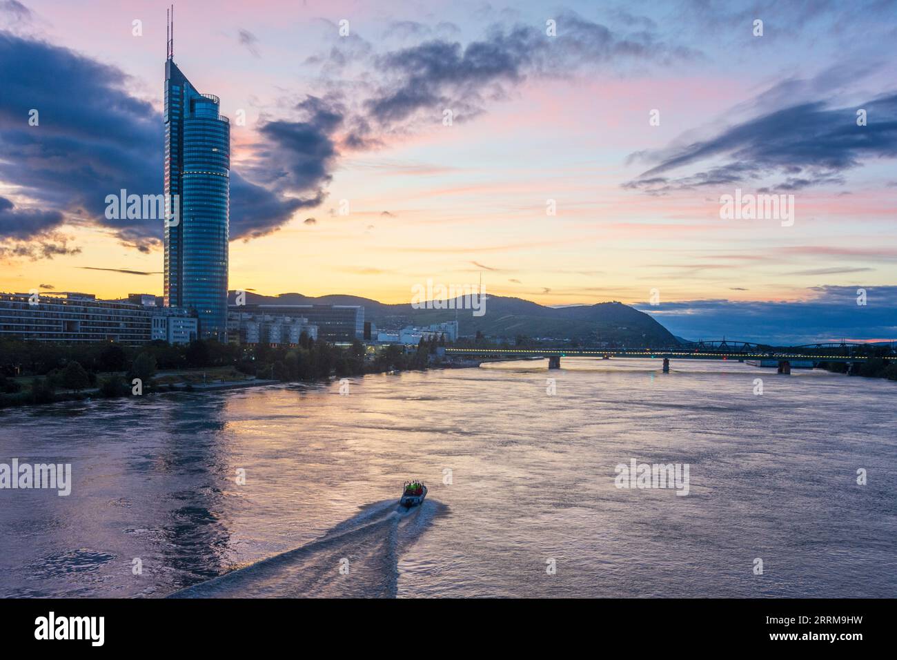 Vienna, fiume Donau (Danubio), Millennium Tower, ponte Nordbahnbrücke, nave di soccorso, tramonto tra 20. Distretto Brigittenau, Vienna, Austria Foto Stock