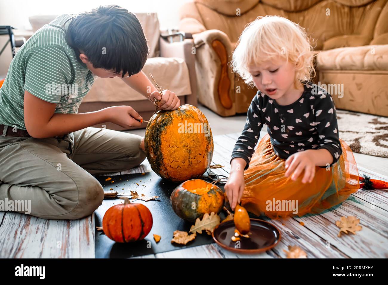 Giovani streghe e ragazzi che lanciano incantesimi sulle zucche per un Halloween incredibilmente buono Foto Stock