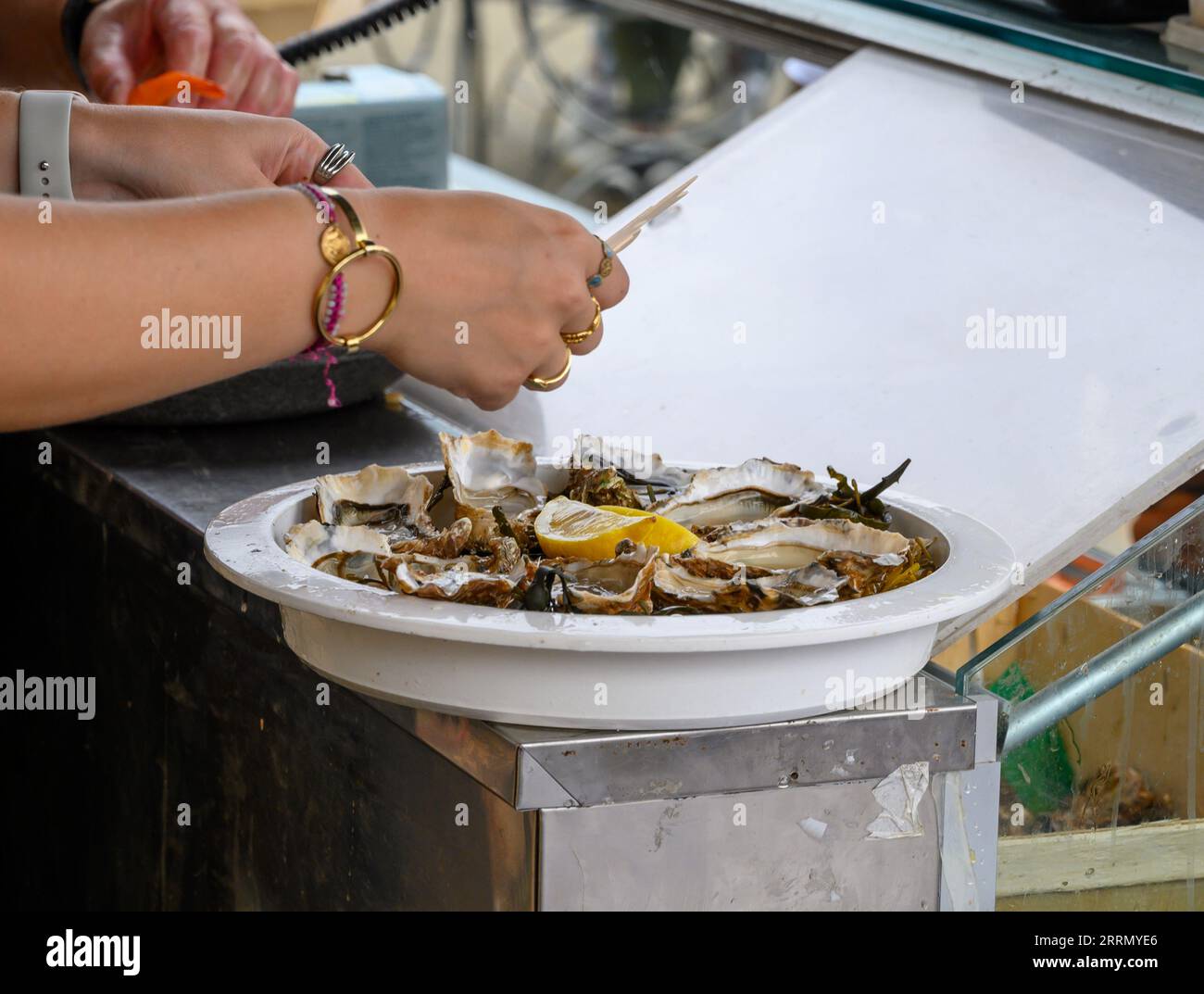 Scacciare i molluschi di ostriche francesi fresche di Gillardeau durante la festa delle ostriche in Normandia, Francia, pronti da mangiare Foto Stock