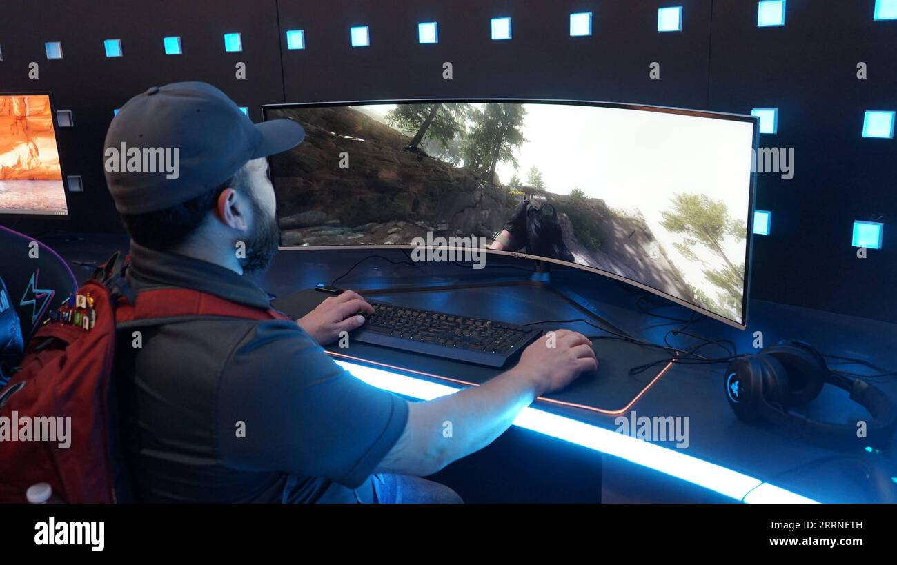 230107 -- LAS VEGAS, 7 gennaio 2023 -- Un uomo sperimenta un mini schermo da gioco curvo a LED da 49 pollici dell'azienda cinese TCL durante il Consumer Electronics Show CES 2023 a Las Vegas, negli Stati Uniti, 6 gennaio 2023. I marchi cinesi di elettronica di consumo hanno lanciato una vasta gamma di prodotti innovativi al CES 2023, tenutosi questa settimana a Las Vegas. PER ANDARE CON Roundup: Le innovazioni tecnologiche cinesi brillano al CES 2023 foto di /Xinhua U.S.-LAS VEGAS-CES-CHINESE COMPANIES ZengxHui PUBLICATIONxNOTxINxCHN Foto Stock