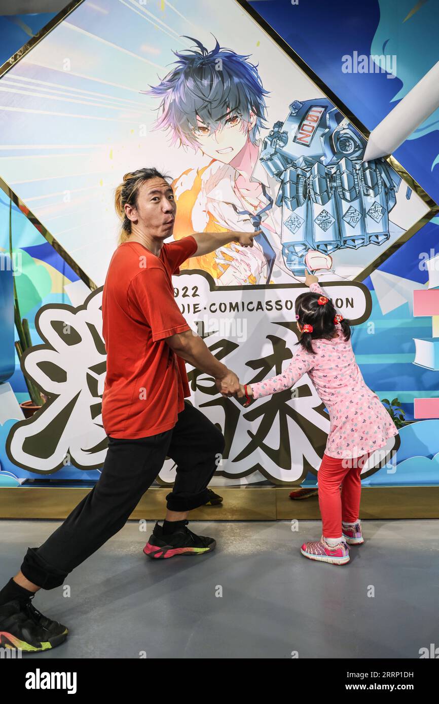 230210 -- HAIKOU, 10 febbraio 2023 -- il cartoonista Liu KE e sua figlia posano per una foto di fronte al suo lavoro nella sala espositiva di una base di incubazione di animazione nel villaggio di Changxue di Longqiao Town, Haikou City, South China S Hainan Province, 9 febbraio 2023. Promuovendo attivamente lo sviluppo dell'industria dell'animazione, Changxue Village ha attratto un certo numero di imprese di animazione e vignettisti a stabilirsi. Liu KE, autore dei popolari fumetti Crazy Neighbors, e sua moglie Meng Qingnan sono tra i primi fumettisti che si sono trasferiti nel villaggio per vivere e lavorare. Lo sviluppo Foto Stock