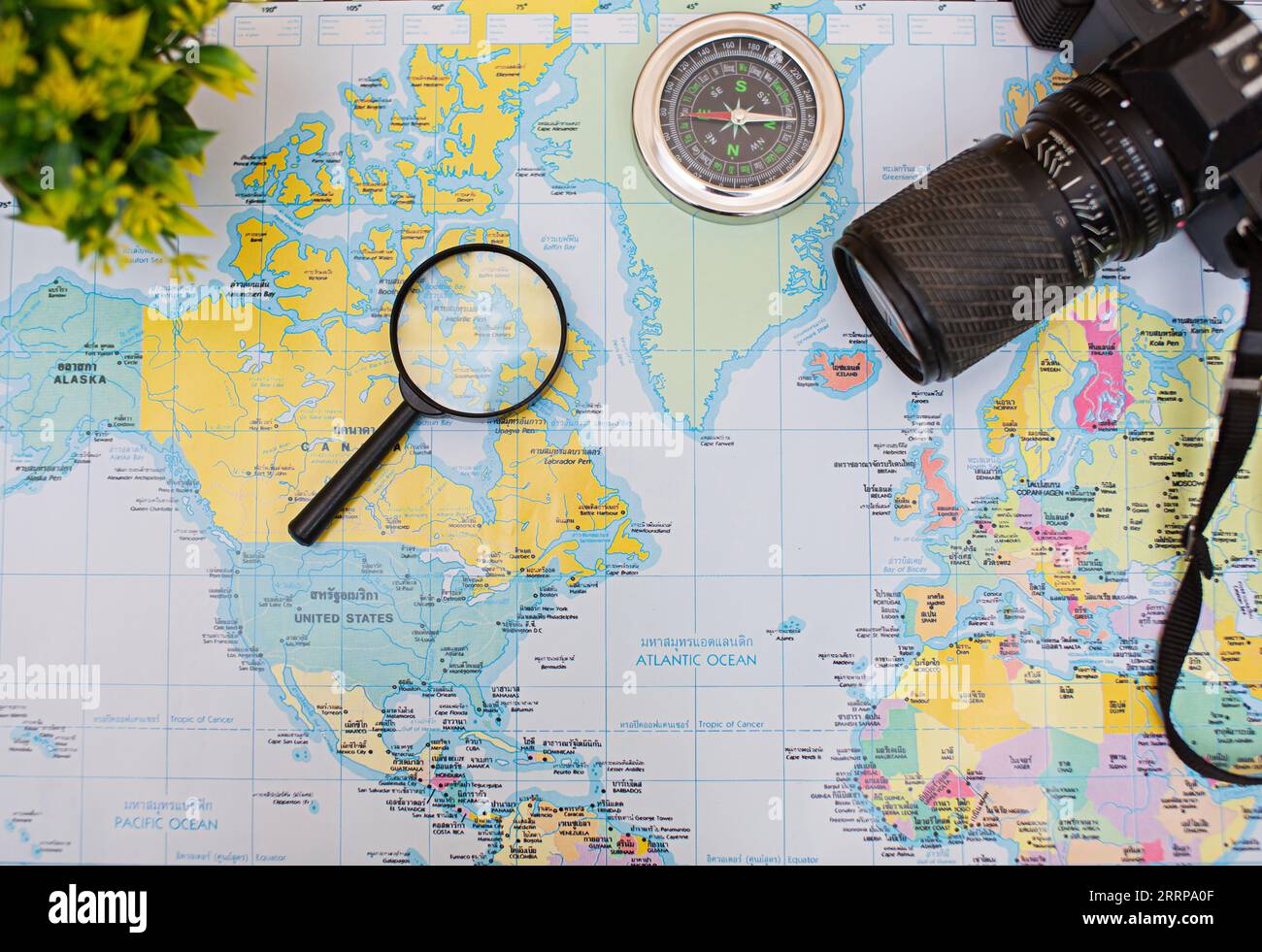 Pianifica un viaggio di vacanza con l'aiuto di una mappa del mondo con altri accessori di viaggio. Foto Stock